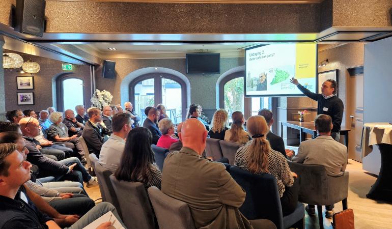 Deelnemers aan de VIP Innovatiedag luisteren naar een presentatie.